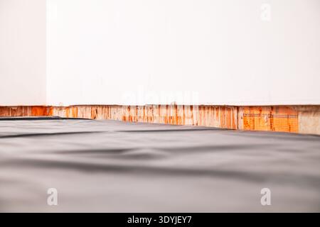 Close-up of a horizontal groove cut into a wall near the floor, prepared for installing concealed skirting boards in a construction or renovation sett Stock Photo