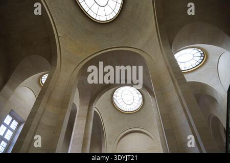 Paris,France-Oct.4th 2025: Low angle shot of the geometric stone arches and circular skylights inside the Louvre. Stock Photo
