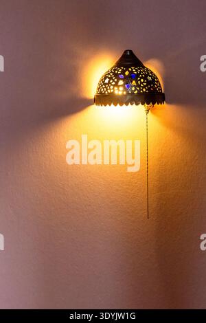 retro arabic wall light on peach painted wall installed during apartment renovation Stock Photo