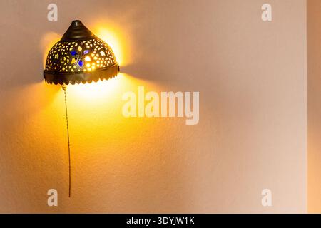 retro arabic wall lamp on peach painted wall installed during apartment renovation Stock Photo