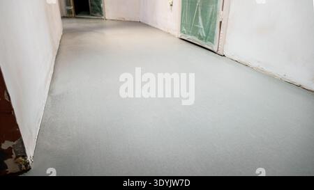 view of self-leveling floor in hallway during renovation of city apartment Stock Photo