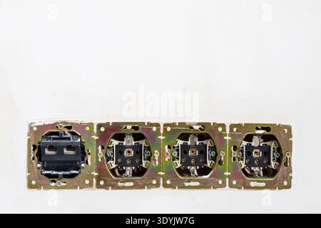 disassembled electrical sockets in plastered wall of room close up during renovation of city apartment Stock Photo