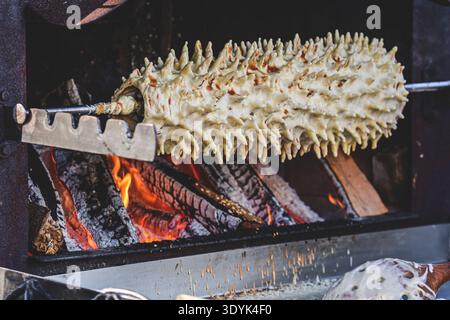Preparing Lithuanian tree cake, šakotis or baumkuchenas, Polish sękacz, Belarusian bankucha, German baumkuchen made of butter, egg whites and yolks Stock Photo