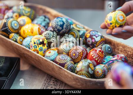 Traditional Lithuanian wooden colorful Easter eggs in a wicker basket, symbol of fertility and life painted with the symbols of nature Stock Photo