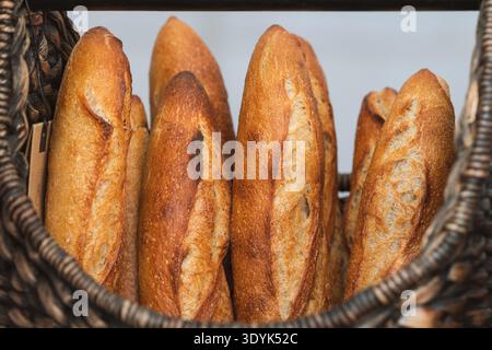 Freshly baked baguettes displayed in wicker baskets at a bakery or street food market Stock Photo