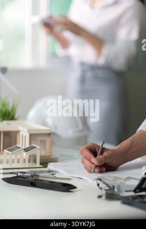 A man is writing on a piece of paper with a pen Stock Photo