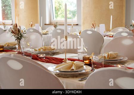 Elegant wedding table decoration with gold accents, eucalyptus greenery and terracotta details. Romantic tablescape for a modern boho wedding Stock Photo