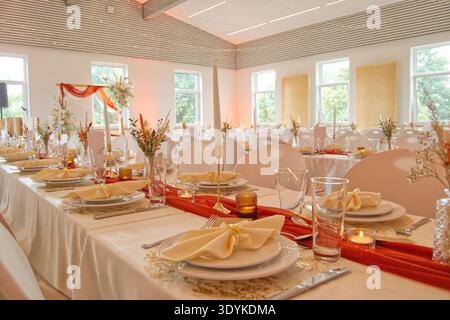 Elegant wedding table decoration with gold accents, eucalyptus greenery and terracotta details. Romantic tablescape for a modern boho wedding Stock Photo