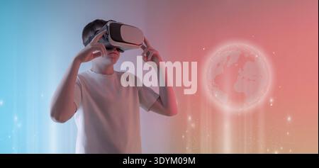Boy using virtual reality headset interacting with holographic digital globe representing global technology, metaverse communication and immersive fut Stock Photo