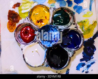 Messy watercolor palette with paint splashes and stains, representing artistic process, creativity, and expressive background. Stock Photo