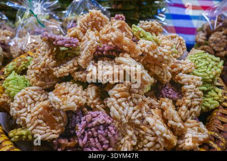 Authentic Thai crispy rice crackers Khao Tan. Traditional puffed rice snack with sugar glaze at a local street food market in Thailand. Stock Photo