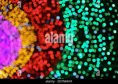 Colorful bokeh lights abstract background with green red yellow and purple zones creating a festive and playful visual atmosphere. Stock Photo