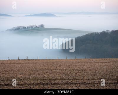 Mist filled valley from the B3081 on Cranborne Chase to the valley of the A30 near Shaftesbury, Dorset, England, UK, March 2020 Stock Photo