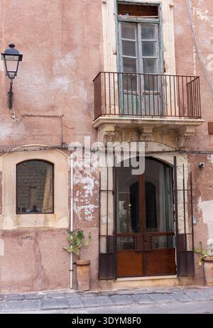 A characterful stucco old building with an old door, windows and lantern Stock Photo