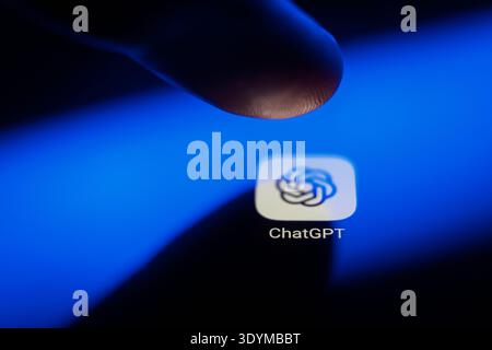 Close-up of a finger about to touch the ChatGPT app icon on a smartphone screen, representing OpenAI's generative artificial intelligence, mobile tech Stock Photo