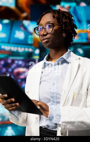 Healthcare researcher using tablet app, looking at medical data, working on disease prevention research. Scientist doing treatment development, looking at patient scans on touchscreen device Stock Photo