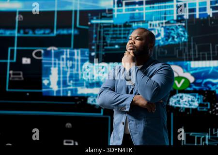African American businessman studying digital AI brain interface, symbolizing neural networks, data science and algorithmic thinking. Cybernetics for a high tech futuristic innovation. Stock Photo