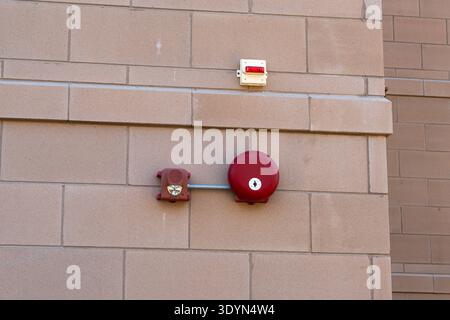 Red outdoor fire alarm detectors mounted on exterior wall of residential building, fire safety and emergency warning system Stock Photo