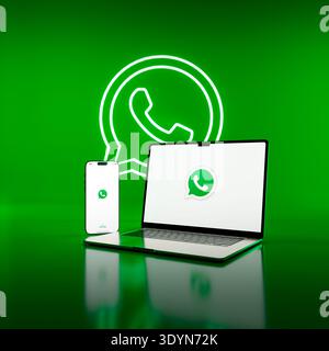 LONDON, UK - MARCH 6, 2026: WhatsApp messaging app on smartphone and laptop with green background, digital communication concept. Stock Photo