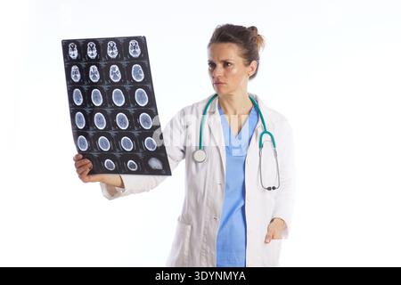 A medical professional looks with concern at a neurological scan, representing diagnostics, radiology, and the serious nature of patient health examin Stock Photo