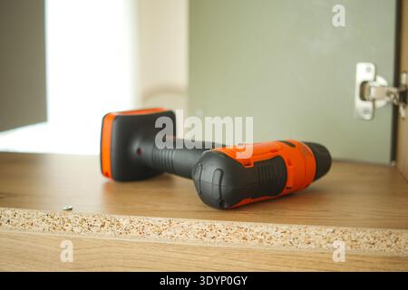 Electric drill on wooden surface in a workshop setting Stock Photo