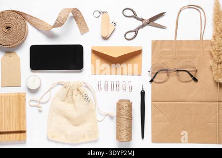 Composition with mobile phone, packaging items and delivery paper bag on white background Stock Photo