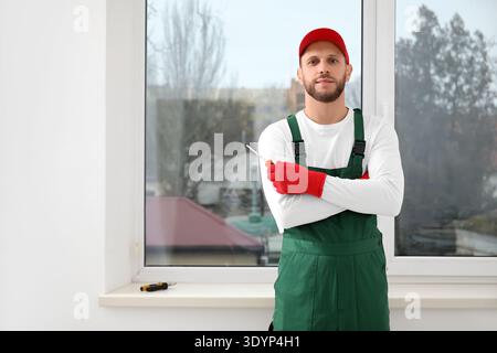 Male worker with screwdriver near window in room Stock Photo