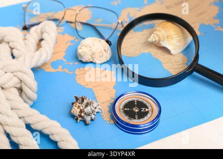 Composition with modern compass, magnifier, rope and world map on white background, closeup Stock Photo