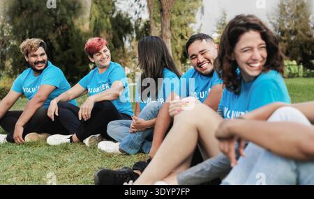 Diverse group of volunteer people celebrating together outside. Youth community and charity support concept. Stock Photo