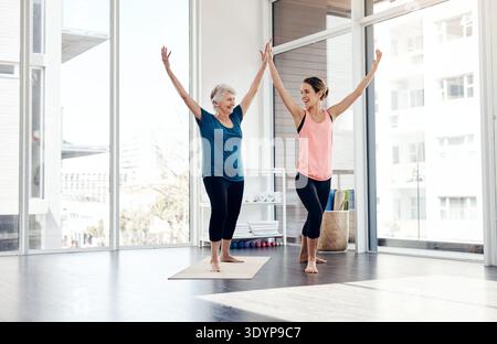 Old woman, help and instructor in yoga class, fitness and conversation with happiness. Trainer, retirement activity and people in facility, exercise Stock Photo