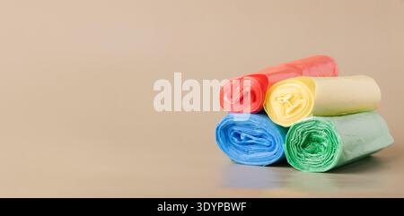 Multi-colored trash bag rolls for household waste disposal, promoting recycling, waste sorting Stock Photo