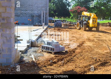 Workers are using heavy machinery arranging building materials at construction site Stock Photo