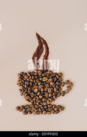 Coffee beans and grounds are arranged in the form of a steaming cup of coffee on a light background Stock Photo