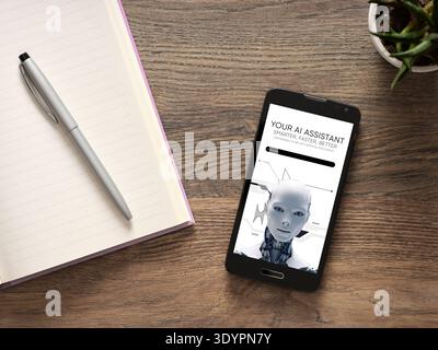 Smartphone showing Your AI Assistant app with a robot head on screen, resting beside a pen and notebook. AI technology concept Stock Photo