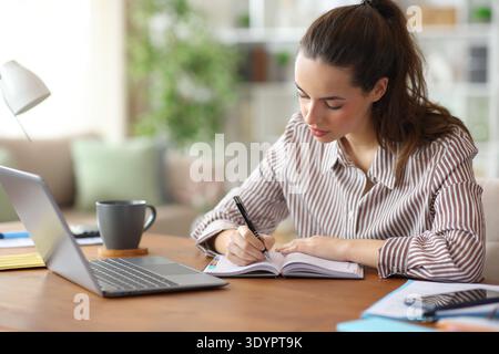 Serious entrepreneur writing notes in paper agenda working at home Stock Photo