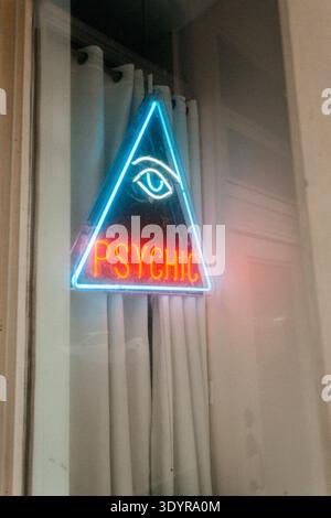 Neon triangle sign with eye and “Psychic” text in window. Stock Photo