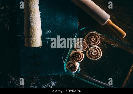 Cinnamon Rolls Getting Sliced and Placed Stock Photo