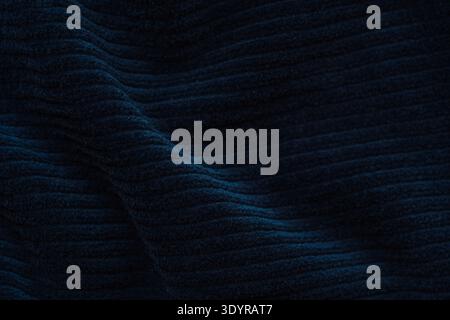 Dark navy ribbed fabric texture with soft folds, minimal textile background Stock Photo