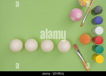 Easter Crafting. Paint and eggs ready for decoration on green background. Stock Photo