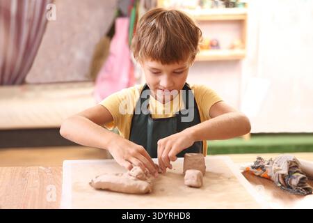 Kids molded from clay at pottery class. || Model released Stock Photo