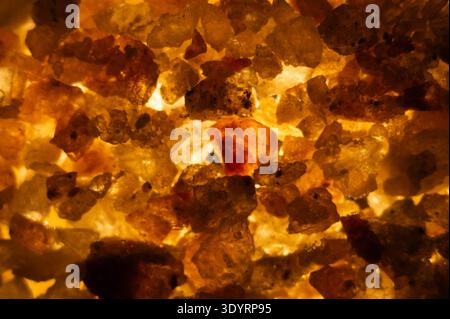 Close-up of raw rock salt illuminated from within at the historic salt mine in Hallstatt, Austria, showing natural crystalline formations extracted fr Stock Photo