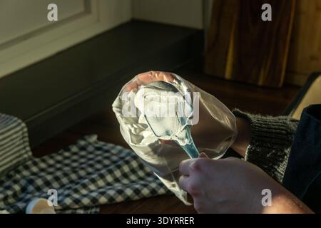 Person fills a pastry bag with whipped meringue using a silicone spatula. Stock Photo