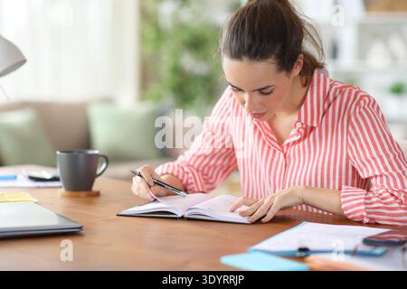 Serious self employed working consulting paper agenda at home Stock Photo