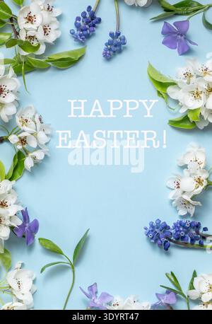 Happy Easter. Flat lay frame from spring flowers on a light blue background. View from above. Beautiful floral frame. Stock Photo