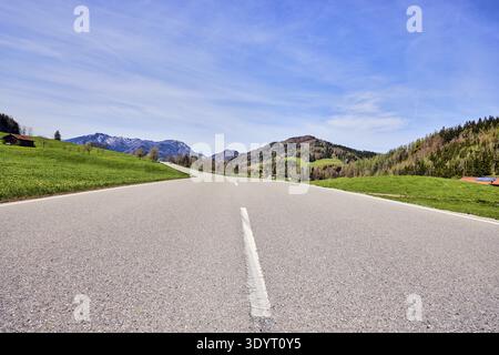 Mountain landscape, meadows, mountains, hills, coniferous forest, homesteads, road, curve, frog-eye view, image processing brightnesses and contrasts Stock Photo