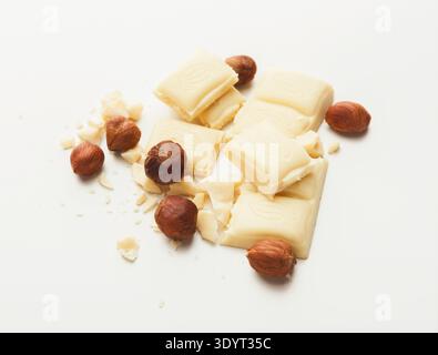 Broken white chocolate bar and hazelnuts isolated Stock Photo