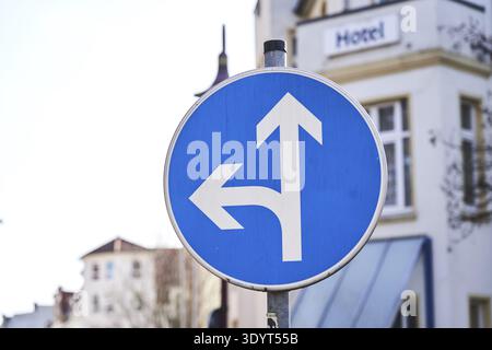 Decision making, turning straight ahead or left in front of a hotel, road sign in a city, in the city field in Magdeburg, Saxony-Anhalt, Germany, traf Stock Photo