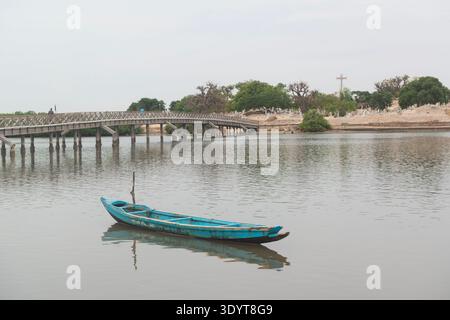 View of the wooden walkway connecting Fadiouth Island to the communal Christian/Islamic island cemetery. Senegal. Canoe in the foreground Stock Photo