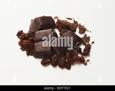 Broken dark chocolate bar and raisins isolated Stock Photo