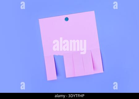 Pink tear off flyer with multiple detachable tabs and one strip torn away on purple background. Blank notice template for advertisements or contact te Stock Photo